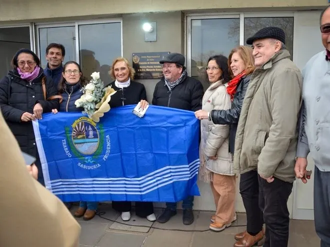 Un grupo de personas emocionadas sostiene la bandera de Salto